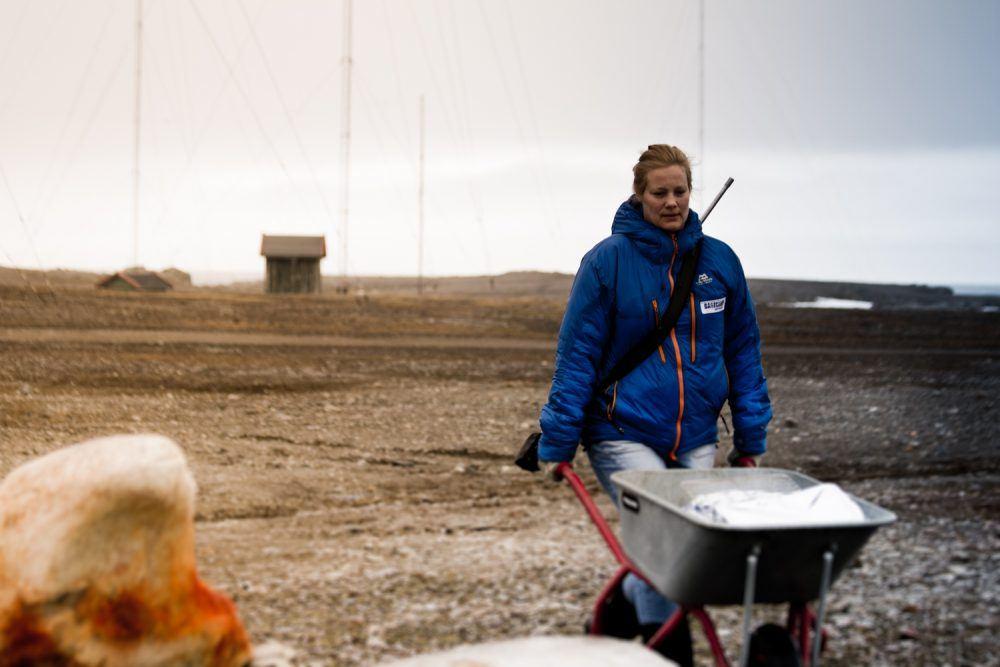 Woman with wheelbarrow at Isfjord Radio on Svalbard.