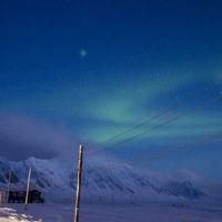 Green northern lights above Basecamp Explorer Isfjord Radio Adventure Hotel on Svalbard.